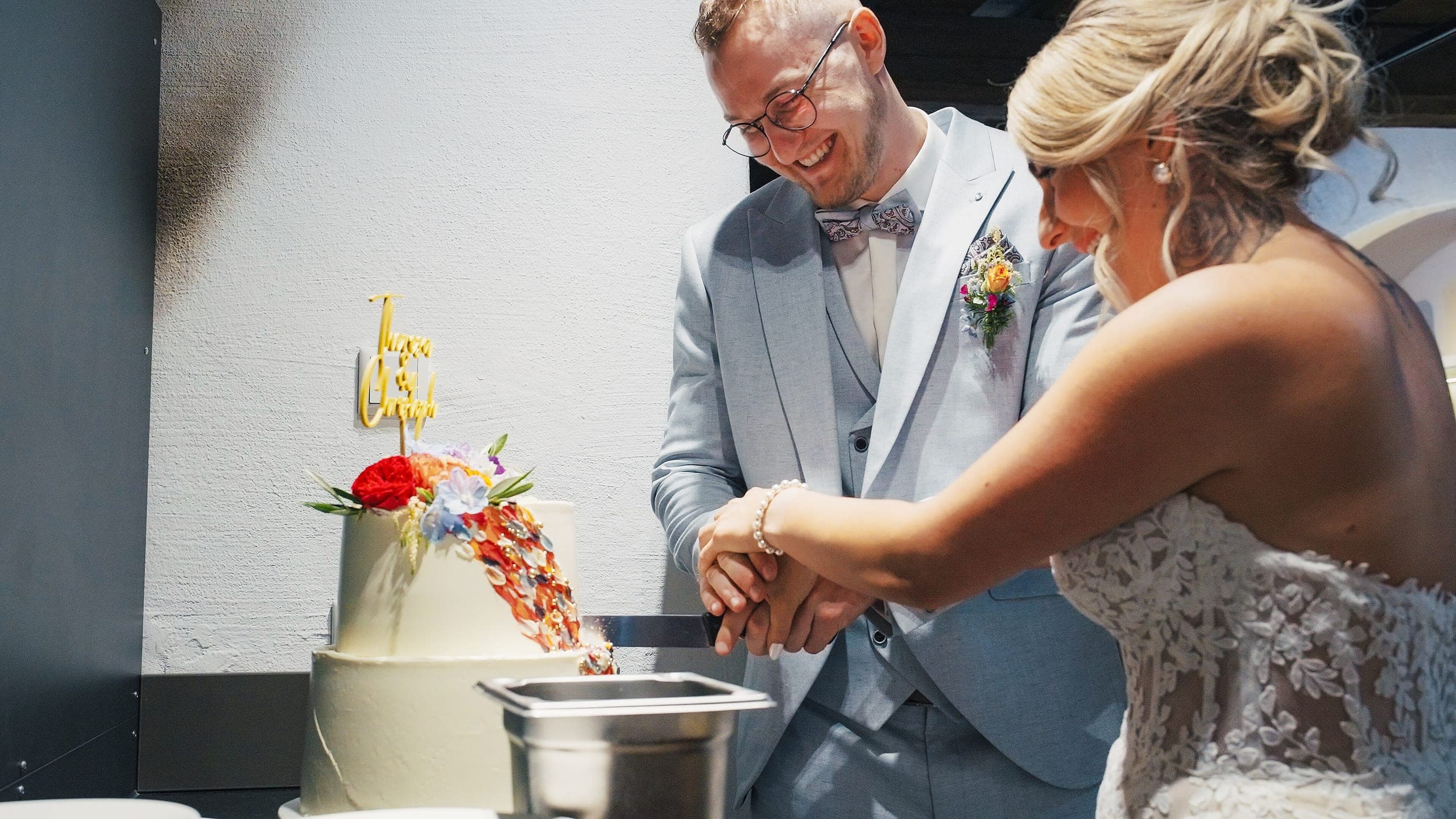 Brautpaar schneidet gemeinsam die Hochzeitstorte an